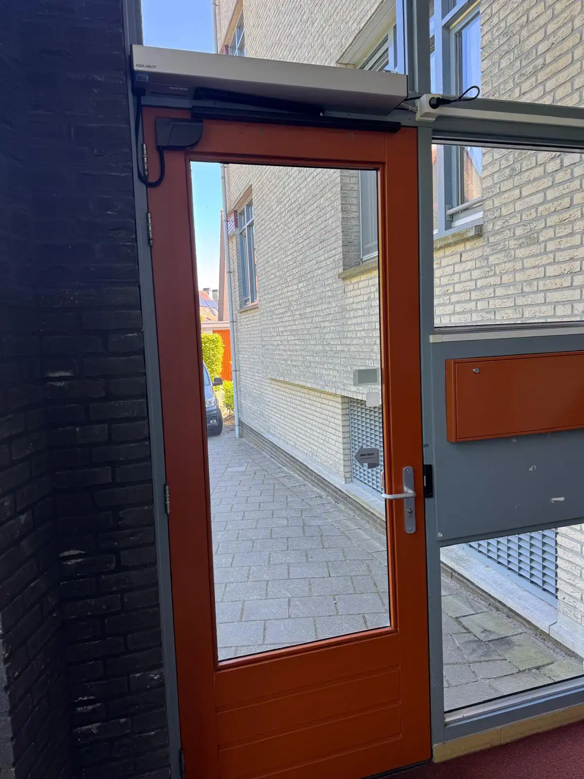 Buitendeur met draaideurautomaat, gemonteerd op een bestaand kozijn